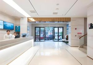 two people sitting at a counter in a hospital lobby at City Comfort Inn Guangzhou Southern Hospital Tonghe Metro Station in Guangzhou