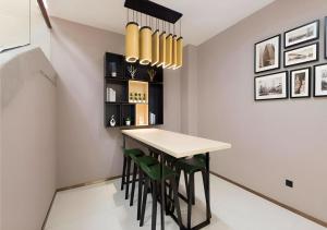 a dining room with a table and green chairs at City Comfort Inn Guangzhou Southern Hospital Tonghe Metro Station in Guangzhou