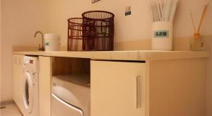 湛江City Comfort Inn Zhanjiang Middle Renmin Avenue Dingsheng Square的厨房配有柜台和洗衣机。