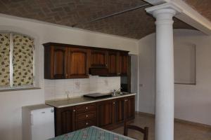 a kitchen with wooden cabinets and a column in it at Agriturismo Lucchetta in Reggiolo