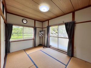 a room with two windows and a clock on the wall at アイランズステーション in Setouchi