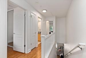 a white hallway with a white door and a staircase at Luxury Oasis Resort Villa in Honokai Hale +32 photos