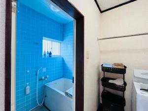 a blue tiled bathroom with a tub and a sink at アイランズステーション in Setouchi +38 photos