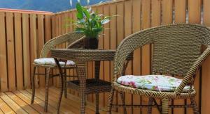 two wicker chairs and a table with a potted plant at Vatica Hotel Huangshan South Gate Terminal Station in Huangshan Scenic Area