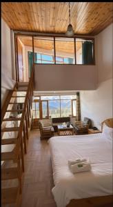a bedroom with a large bed and a staircase at Hotel BHRIGU in Manāli