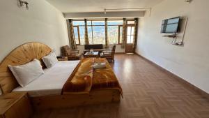 a bedroom with a large bed and a living room at Hotel BHRIGU in Manāli +109 photos