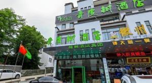 a building with a sign on the side of it at Vatica Hotel Huangshan South Gate Terminal Station in Huangshan Scenic Area