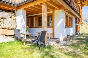 Marmo Apartment by HomeFlow في زيرمات: منزل أمامه طاولة وكراسي +صورة واحدة