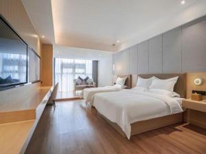 una camera da letto con due letti e una TV a schermo piatto di Gya Hotel Chengdu Global Center Jinchenghu Metro Station a Chengdu Altre 261 foto