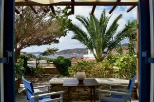 a patio with a table and chairs and a view of the ocean at Fassolou in Faros
