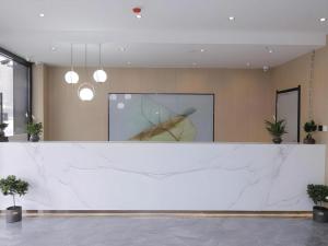 a large white counter in a lobby with potted plants at Green Tree Inn Express Tangshan Kaiping District Government in Dachadao