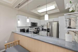 a kitchen with white cabinets and a large counter top at Serene Oasis - Home Away from Home in Honokai Hale