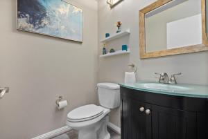 a bathroom with a sink and a toilet and a mirror at Serene Oasis - Home Away from Home in Honokai Hale +17 photos