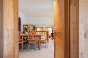 Marmo Apartment by HomeFlow في زيرمات: مطبخ وغرفة طعام مع طاولة وكراسي