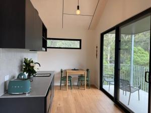 a kitchen and dining room with a table and chairs at Perch Lorne in Lorne
