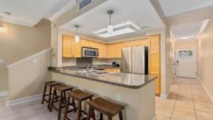 a kitchen with a counter with chairs and a refrigerator at Beautiful 3 Bedroom Villa in Honokai Hale +21 photos