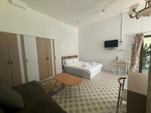 a bedroom with a bed and a table and a couch at Phuket Patong Plan B house in Patong Beach