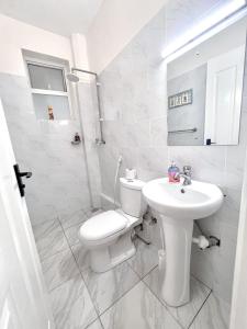 Un baño blanco con inodoro y lavabo. en Cosy apartments, en Mtwapa 10 fotos más
