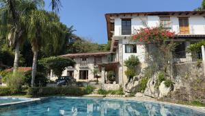 クェツァラン・デル・プログレソにあるHotel Posada La Veredaの家の前にプールがある家