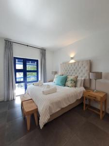 een slaapkamer met een groot bed en een raam bij Okeanós View - 4 Akrotiri in Ballito