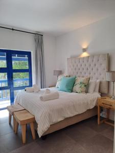 een slaapkamer met een groot bed met een groot raam bij Okeanós View - 4 Akrotiri in Ballito +24 foto's