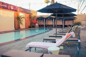 a swimming pool with lounge chairs and umbrellas at Ahern Hotel and Event Center in Las Vegas