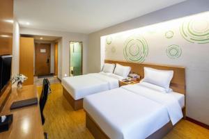 ein Hotelzimmer mit zwei Betten und einem Fernseher in der Unterkunft GYA Hotel Taiyuan Zonggai Zone Ancient County Chengnan Station in Taiyuan + 167 Fotos