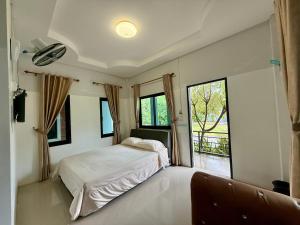 sypialnia z łóżkiem i dużym oknem w obiekcie โรงแรมธารทิพย์ อินน์ หนองคาย รีสอร์ท w mieście Nong Khai