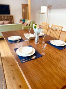 a wooden table with plates and glasses on it at Ajito Niseko in Kutchan +17 photos