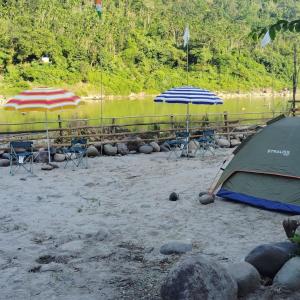 zwei Sonnenschirme, Stühle und ein Zelt am Strand in der Unterkunft Tribe Riverbank Campsite in Dawki + 36 Fotos
