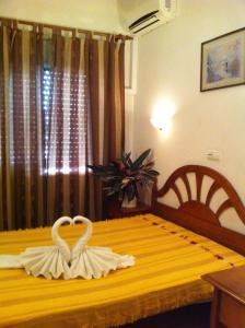 two white swans are sitting on top of a bed at Santa Isabel in Portimão