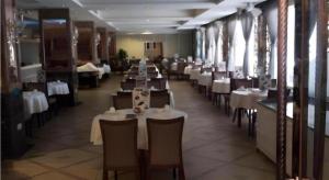 a dining room with white tables and chairs in a restaurant at Shenzhen Nan Fei Yuan Hotel in Shenzhen