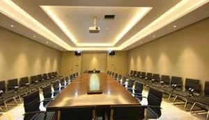 a large conference room with a long table and chairs at Echarm Hotel Shenzhen World Exhibition and Convention Center in Fenghuangwei