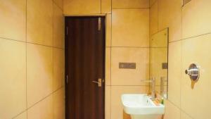 班加罗尔Kings Club的一间带水槽和棕色门的浴室