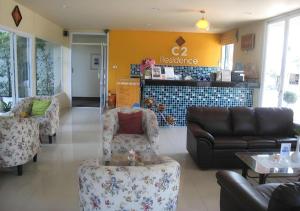 Sathani Nakhon LampangC2 Residence Hotel的一间客厅,客厅里摆放着长沙发和椅子