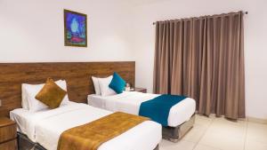 班加罗尔Kings Club的有两张床和一扇窗户的酒店房间