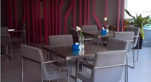 长沙Magnotel Changsha Wuyi Square Metro Station National Finacial Center的一间配备有桌椅和红色窗帘的用餐室