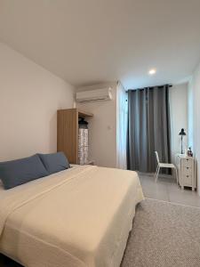 古晋StayCO - D'Millenia Residences - Studio Unit的带一张大床和一把椅子的卧室