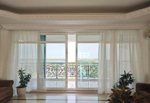 a living room with a large window and a balcony at Zawadi Apartment in Dar es Salaam