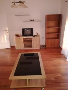 a living room with a tv and a table at Apartman Any Bar in Bar
