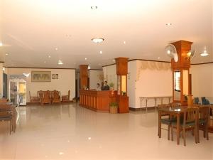 uma sala de estar com mesa e cadeiras e um quarto em Chaleunehoung Hotel em Ban Houadông