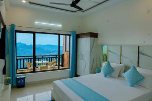 a bedroom with a large bed and a balcony at Hotel Vista, Nainital - A hidden gem away from city hustle in Nainital +17 photos