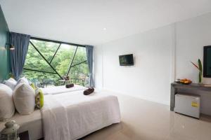 um quarto com uma cama com uma janela grande em The Forest Home Resort em Ban Dong