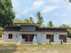 Ban Na LakSuanlamyai Resort的一座黑色屋顶的白色小房子