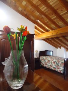 a vase with flowers on a table in a room at Ribeirinha House in Porto Formoso