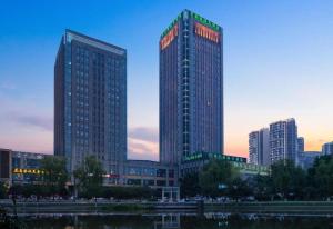 Un palazzo alto in una città al tramonto di Chongqing Huachen International Hotel a Chongqing