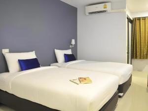 two beds sitting next to each other in a room at U Sleep Chiangmai in Chiang Mai