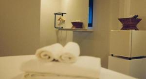 due rotoli di asciugamani seduti su un bancone in bagno di Silp-Pa Phra Nakhon Si Ayutthaya Hotel a Phra Nakhon Si Ayutthaya Altre 224 foto
