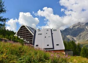 un gran edificio con montañas en el fondo en Appartamenti La Maison de Vacances, en Breuil-Cervinia