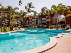 a swimming pool at a resort with palm trees at Baan Pran Boutique Resort in Ban Na Phaniat